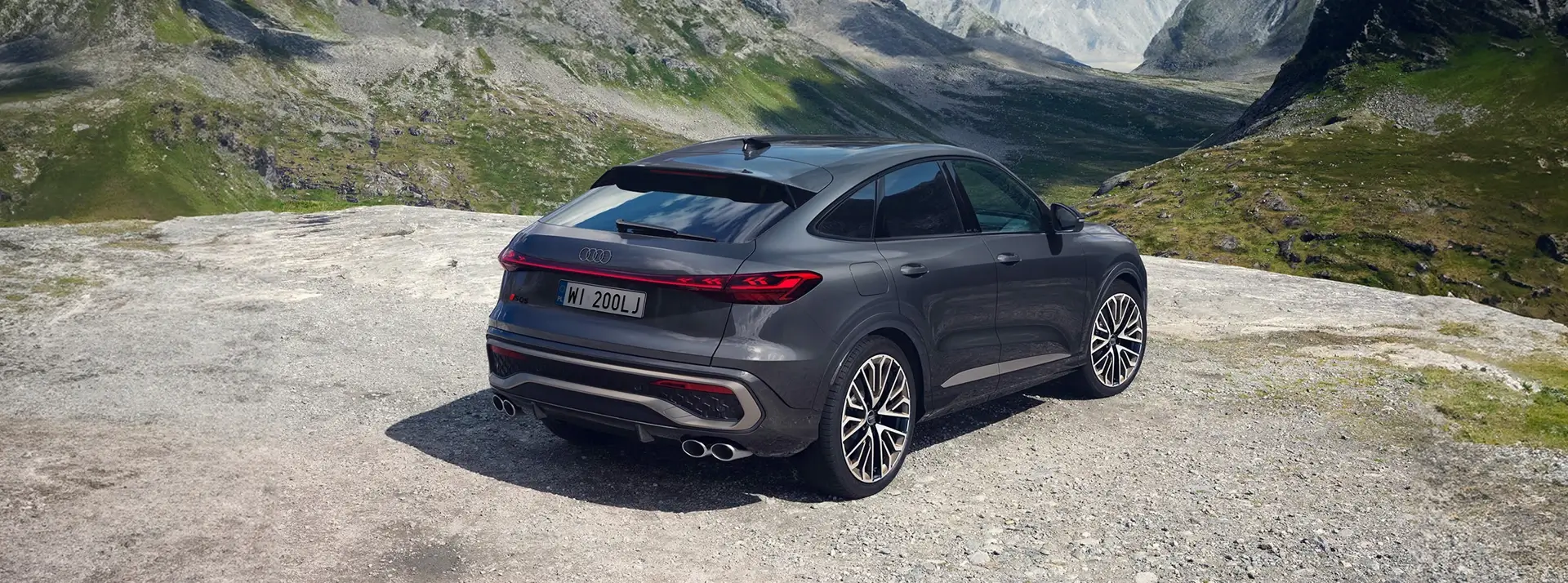 grafitowy SUV Audi SQ5 zaparkowany u podnóża gór